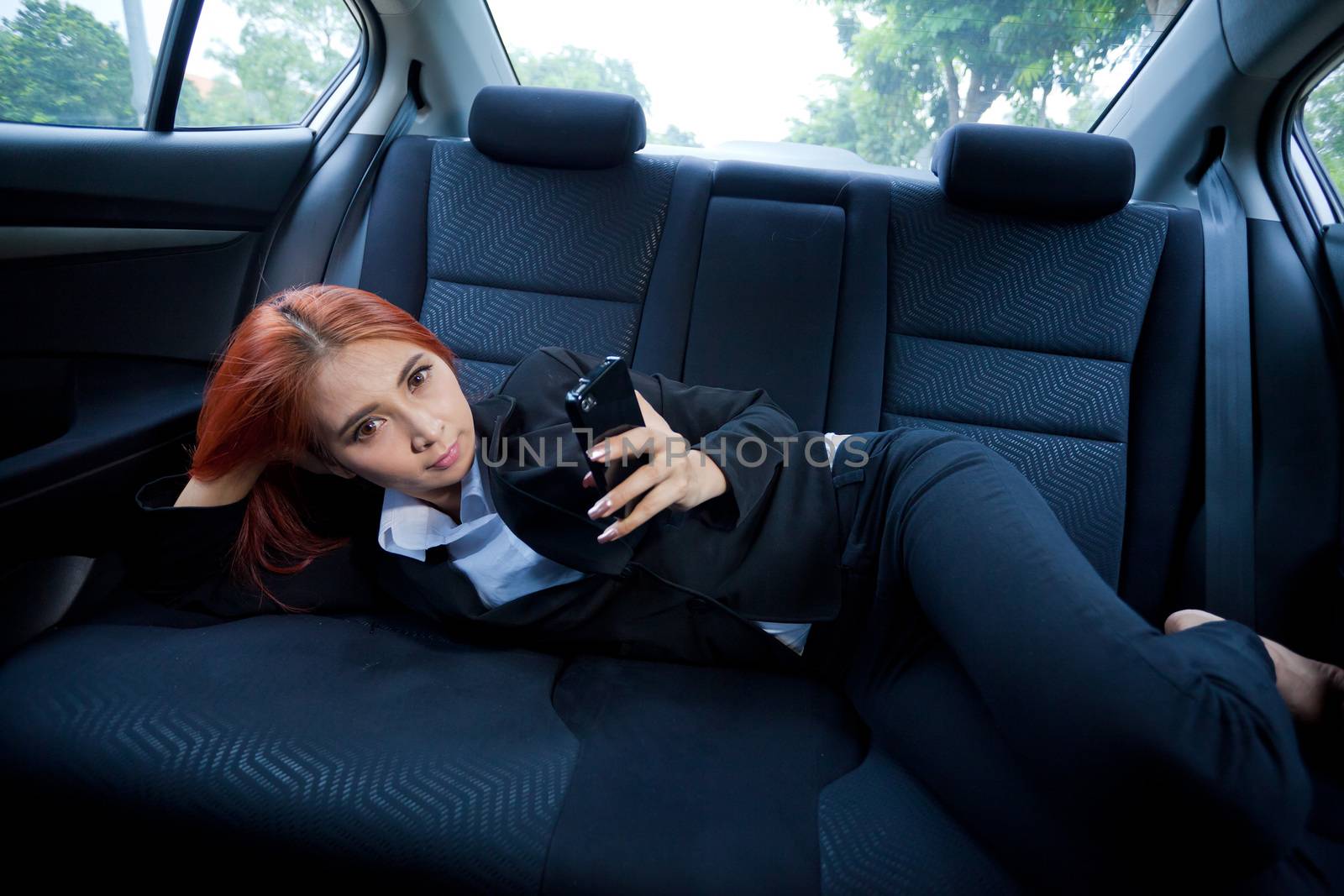 Beautiful young business asian woman using a smart phone in a car