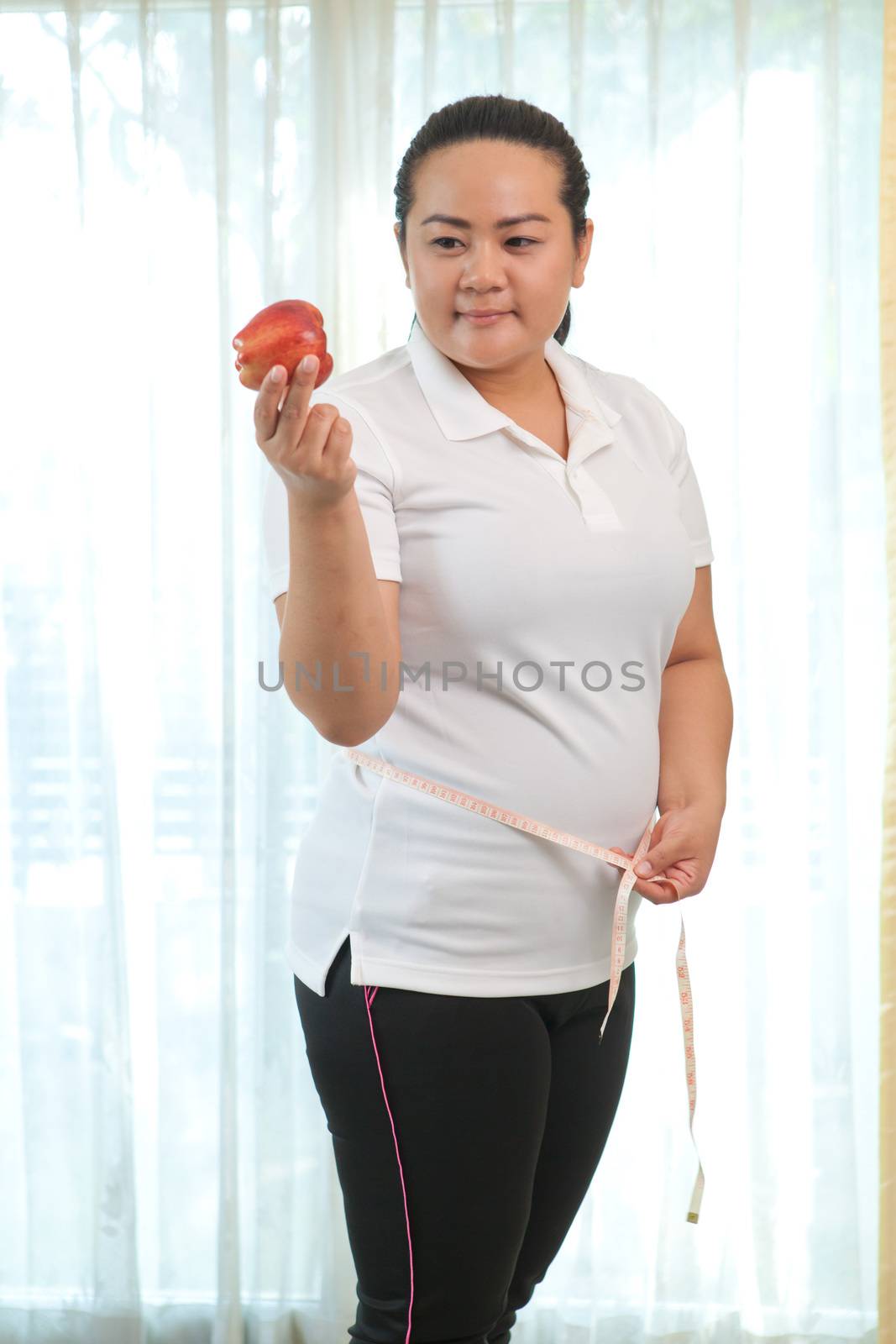 Fat asian woman with apple on white