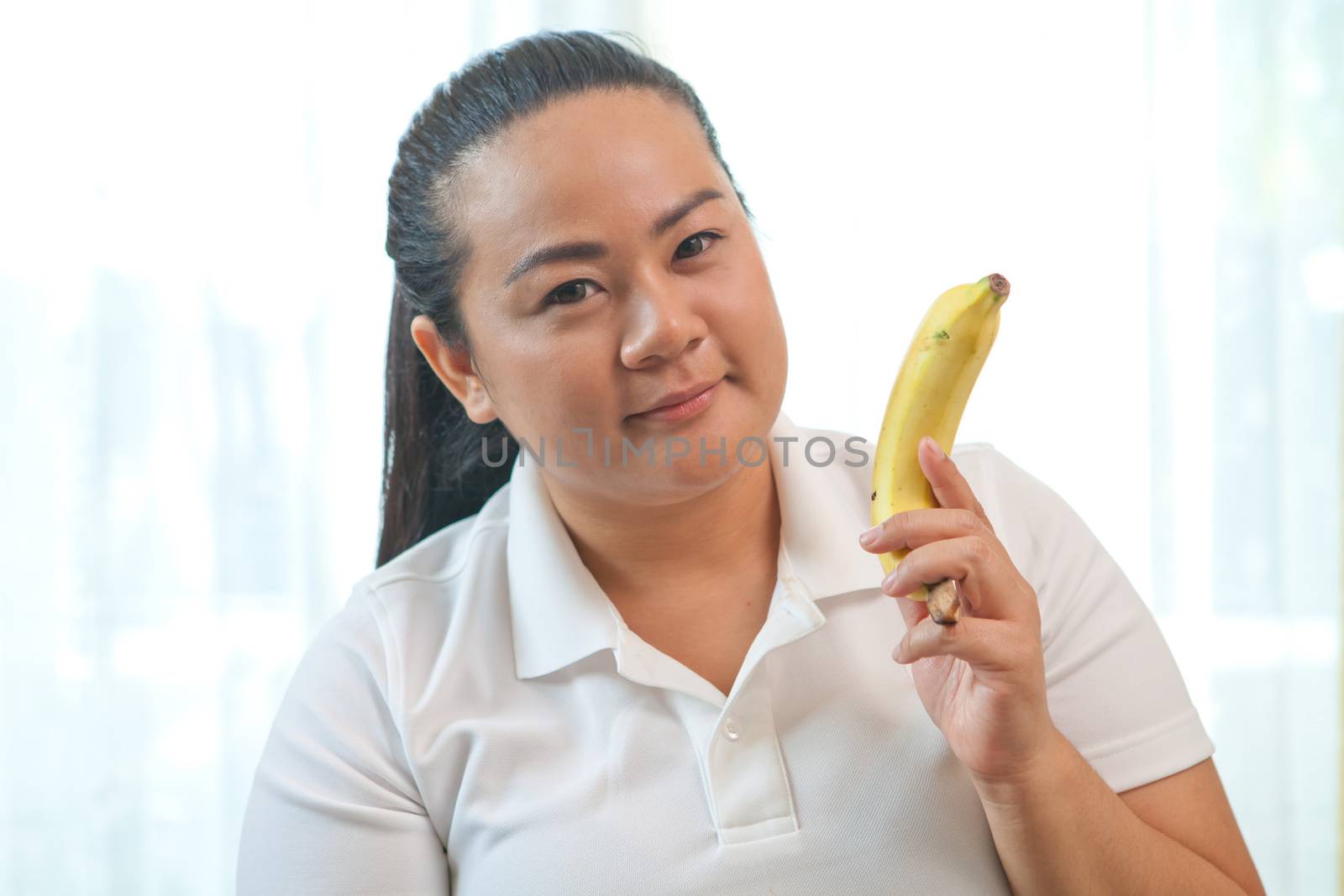 Fat asian woman with banana on white