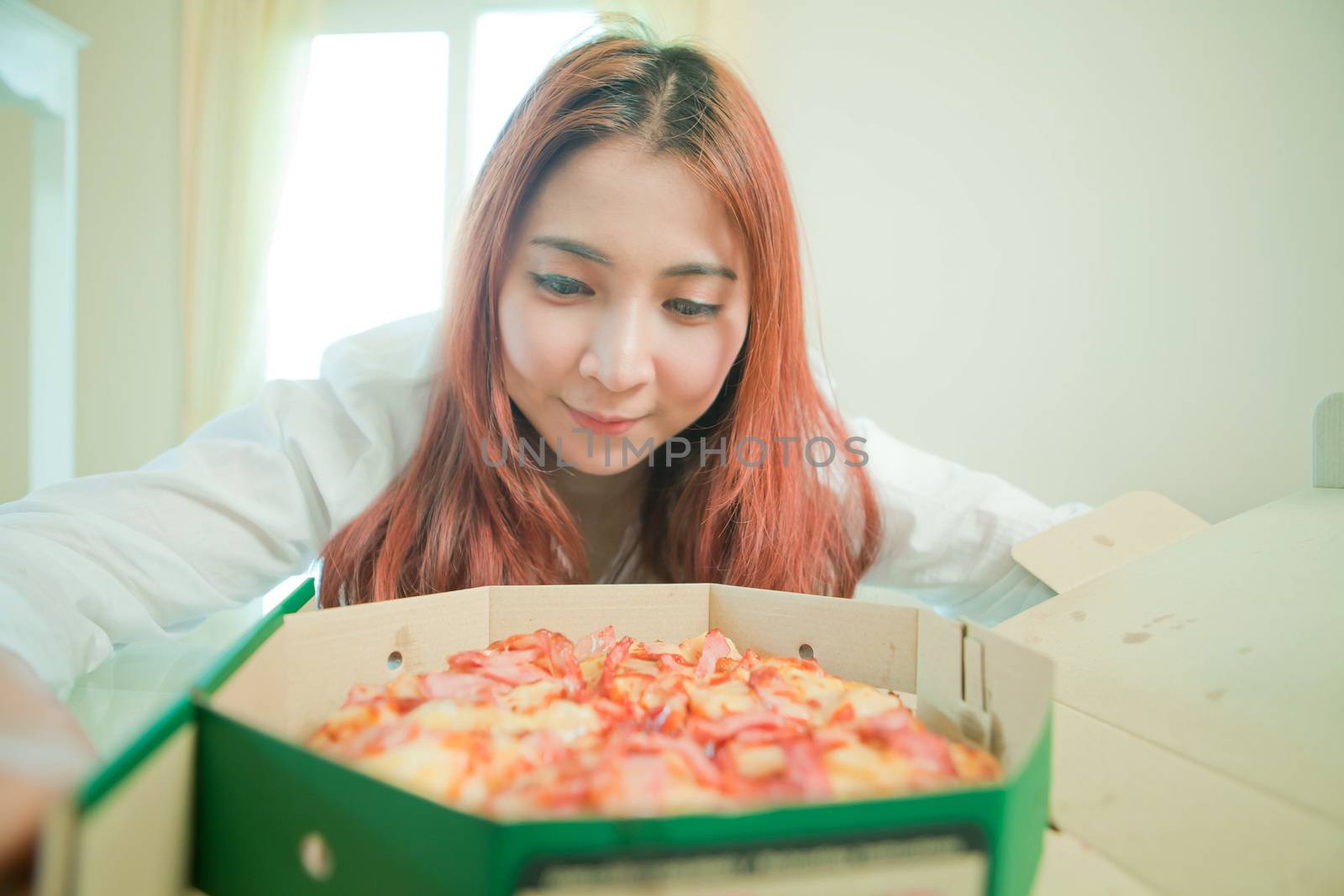 Young asian beautiful woman with pizza at home