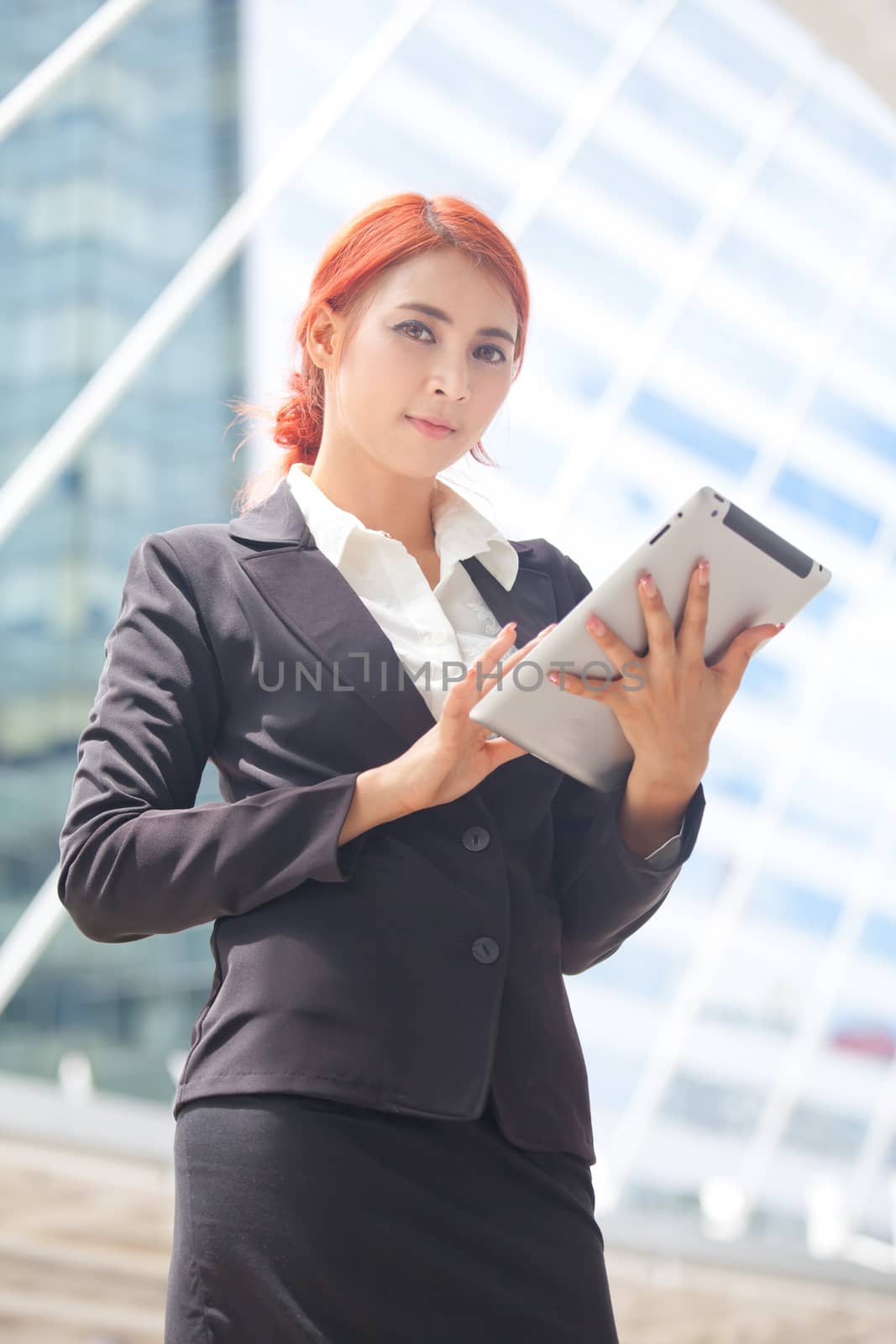 Young business asian woman with tablet at modern city