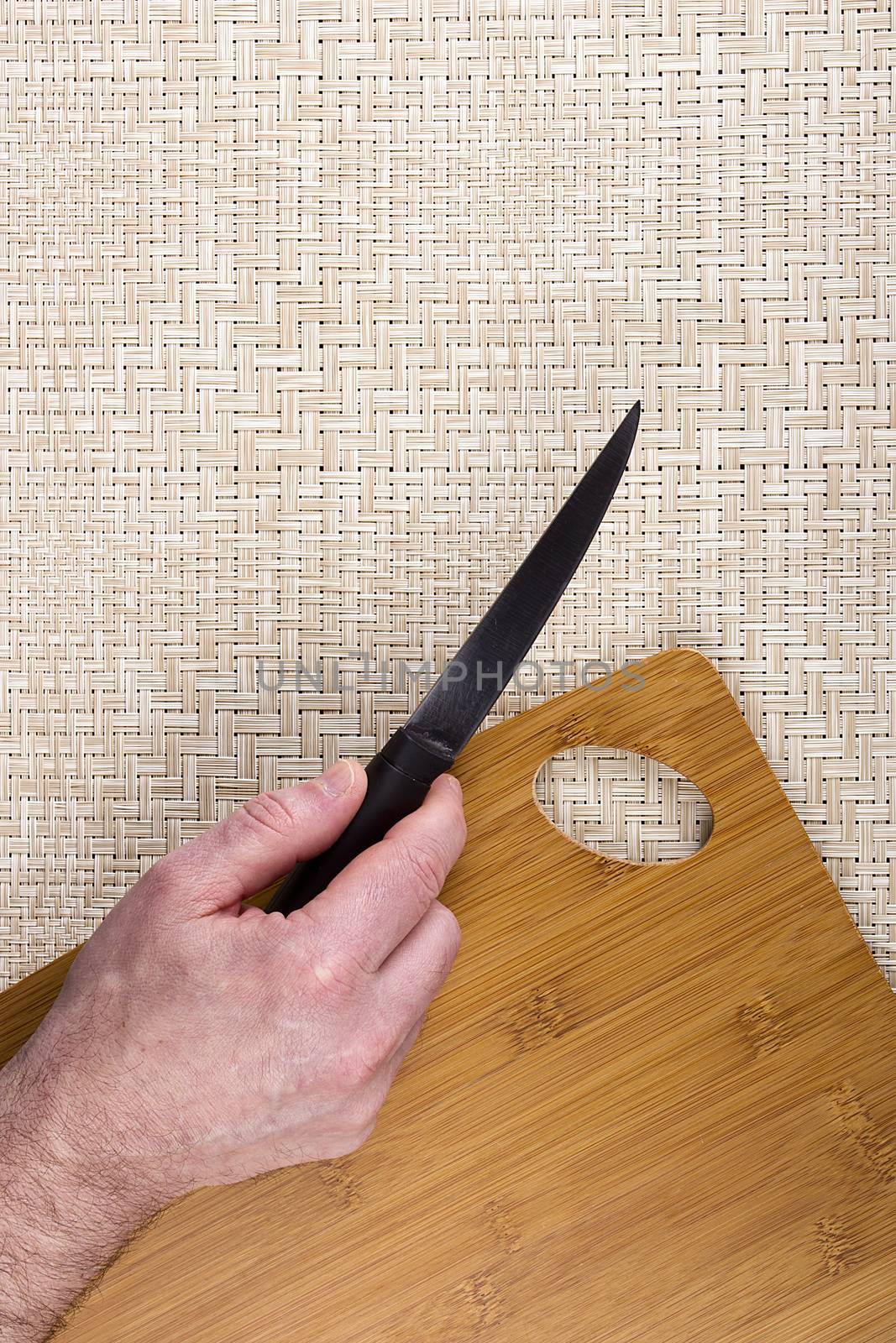 Kitchen knife on a table with a cutting board.