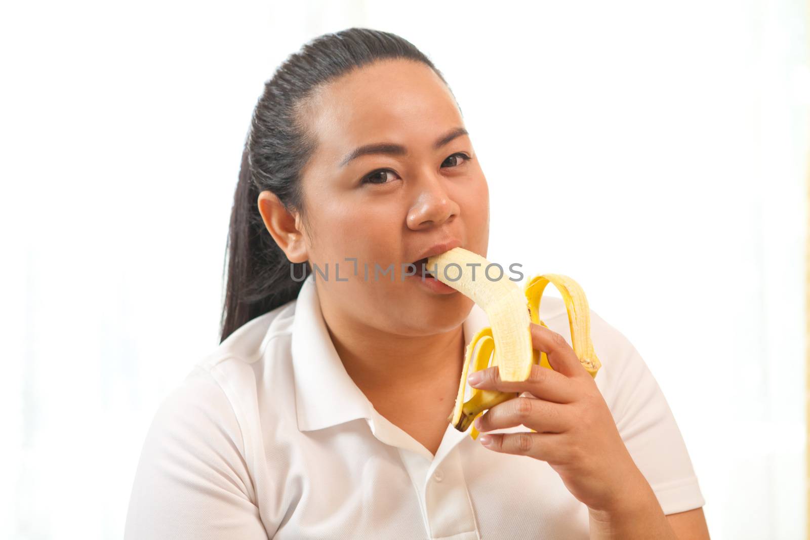 Fat asian woman with banana on white