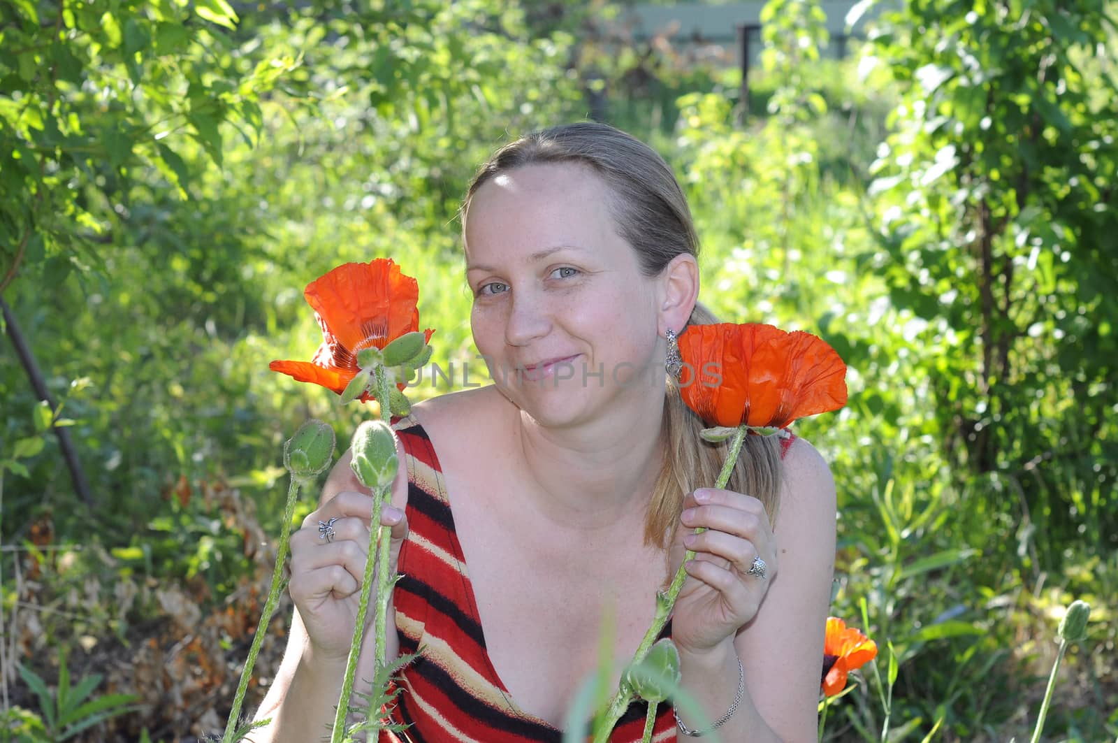 The woman with red poppies in a garden