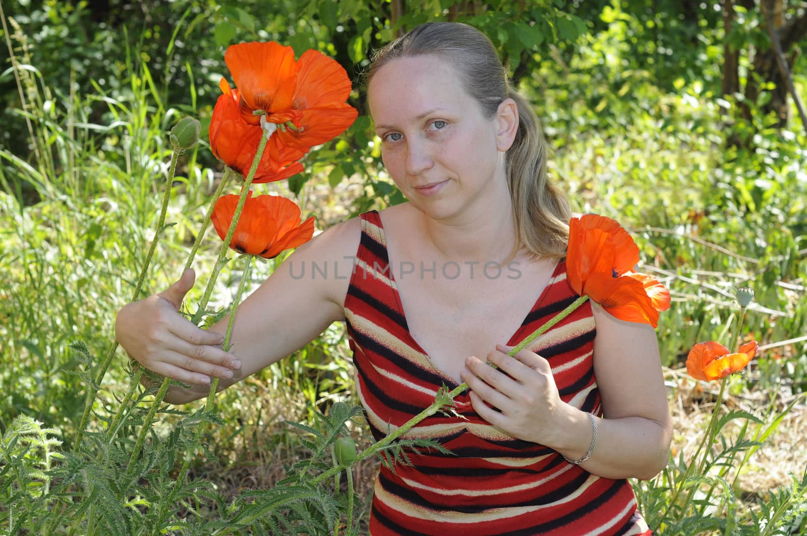 The woman with red poppies in a garden. by veronka72