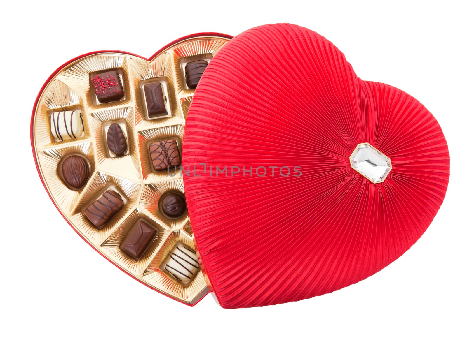 A delicately pleated, red satin, heart shaped box of delicious gourmet chocolates for Valentine's Day.  Isolated with clipping path.