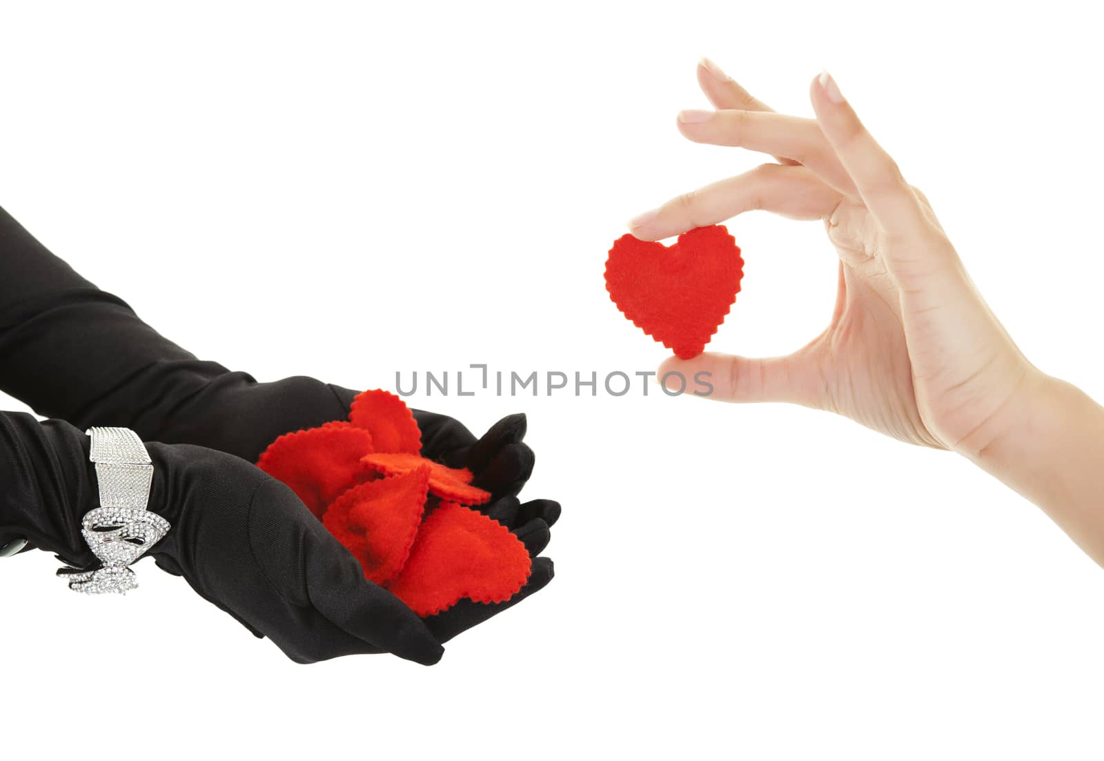 Elegantly gloved hands receive another heart from a female hand.  Shot on white background.