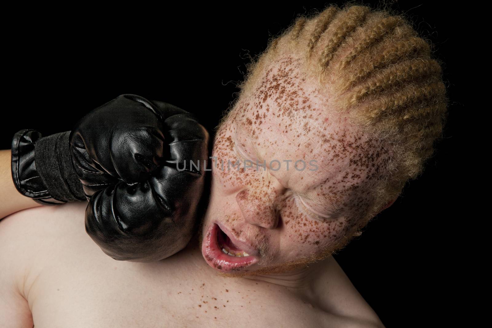 An albino African-American boxer taking a knock out punch to the jaw.  