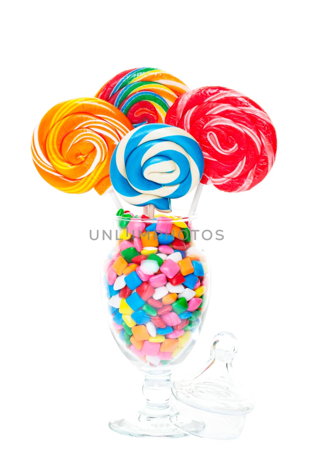 Large swirled lollipops displayed in an apothecary jar full of bubble gum.  Shot on white background.
