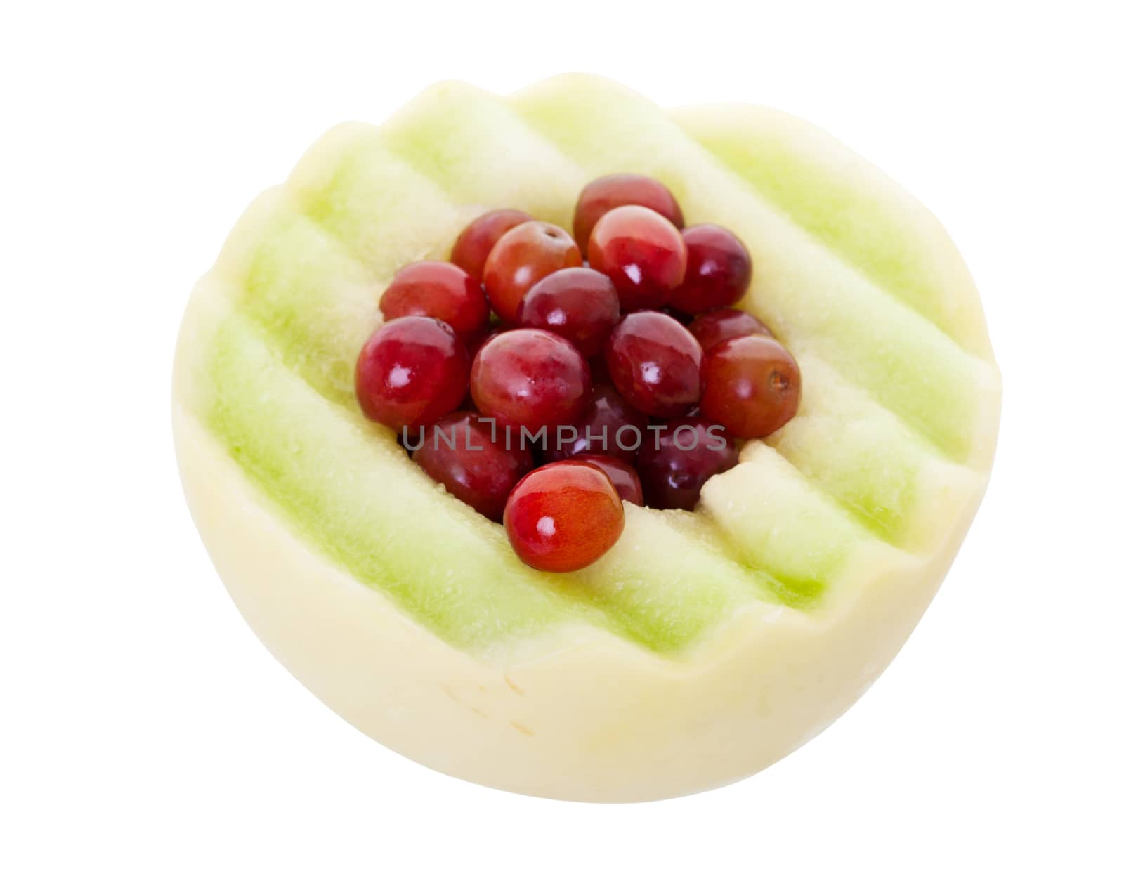 Half of a honeydew melon stuffed with fresh red grapes.  Shot on white background.  With clipping path.