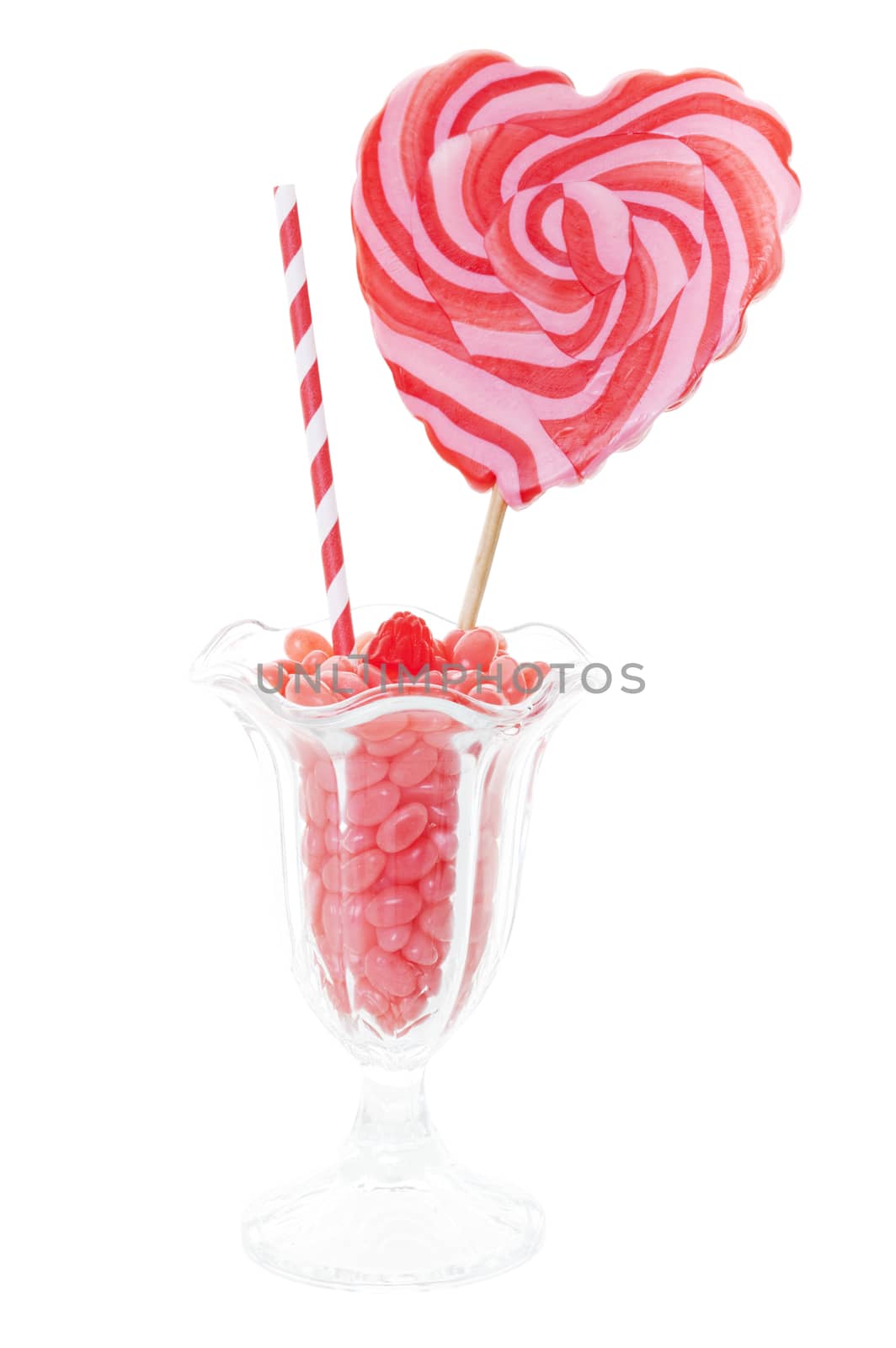 Pink bubble gum flavoured, gourmet jelly beans served in a sundae glass and topped with a raspberry gumdrop and a heart shaped lollipop.  Shot on white background.