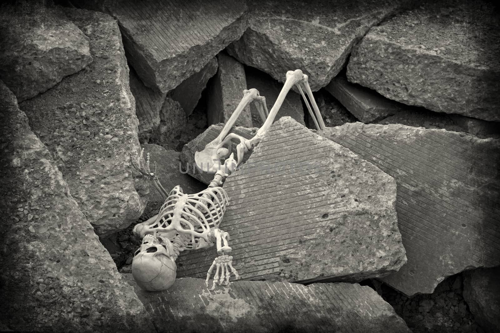 A apocalyptic skeleton rests amongst the rubble of a collapsed building.