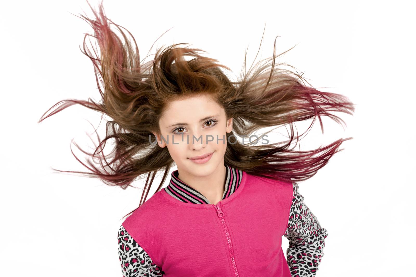 Studio fashion portrait of young beautiful girl with nice eyes on white background with wind from fan in hair