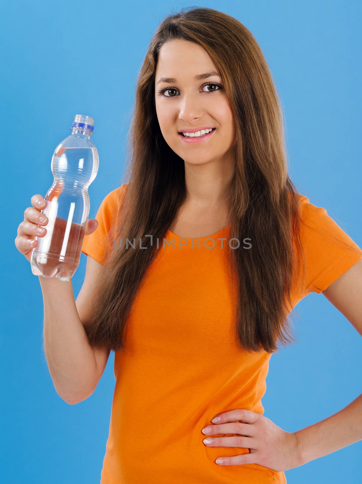 Happy young woman drinking bottled water by sumners