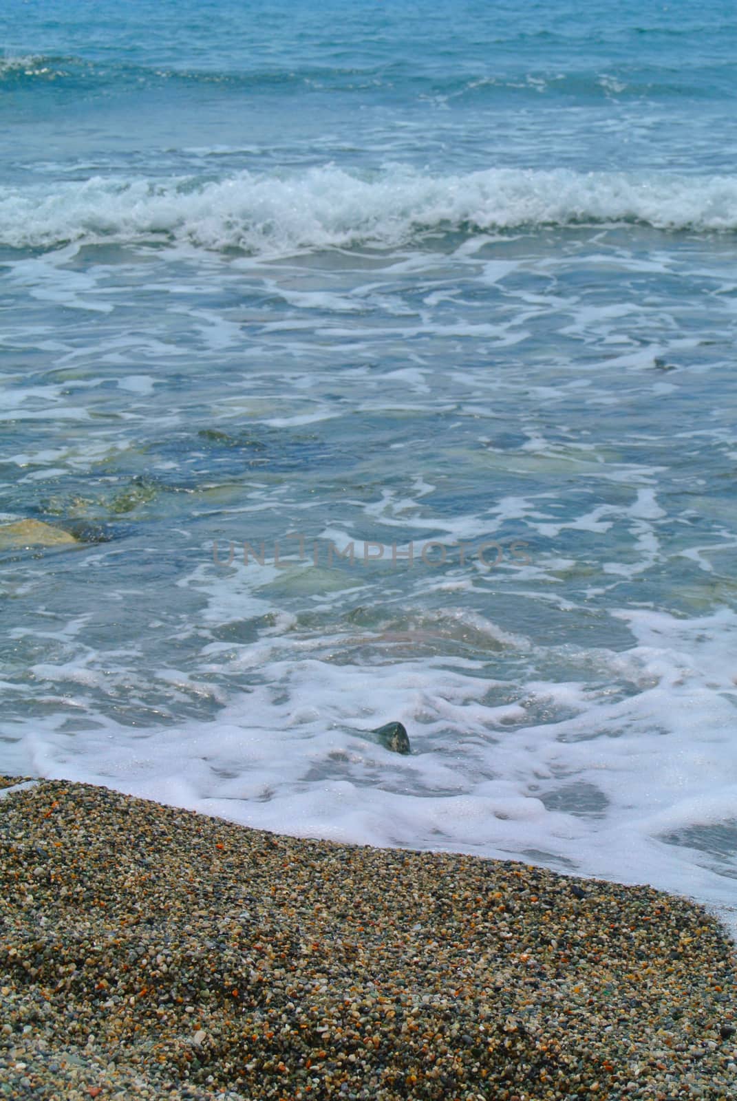 The sea coming to the beach, vertical image