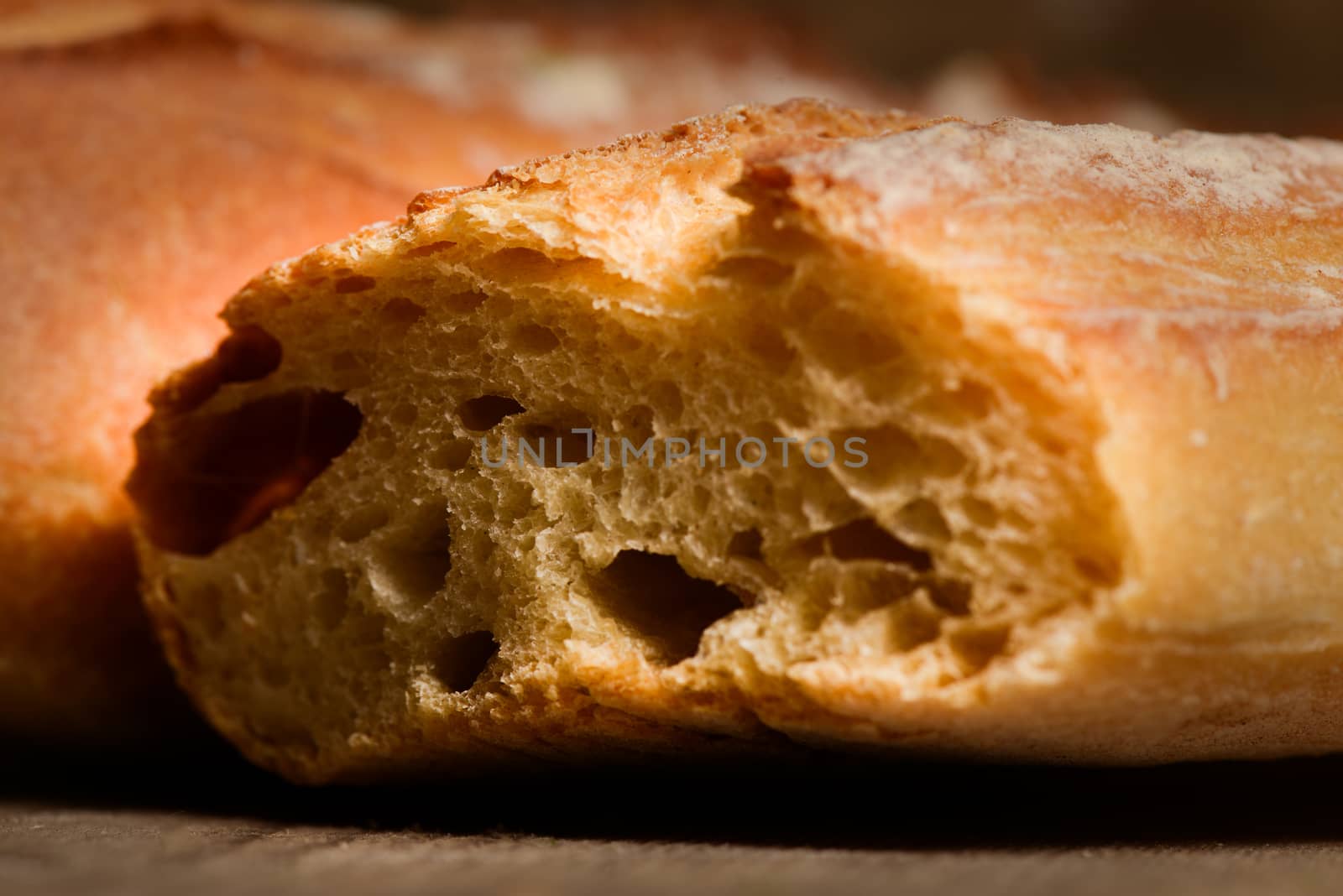 French crusty bread, isolated on a wooden plank background