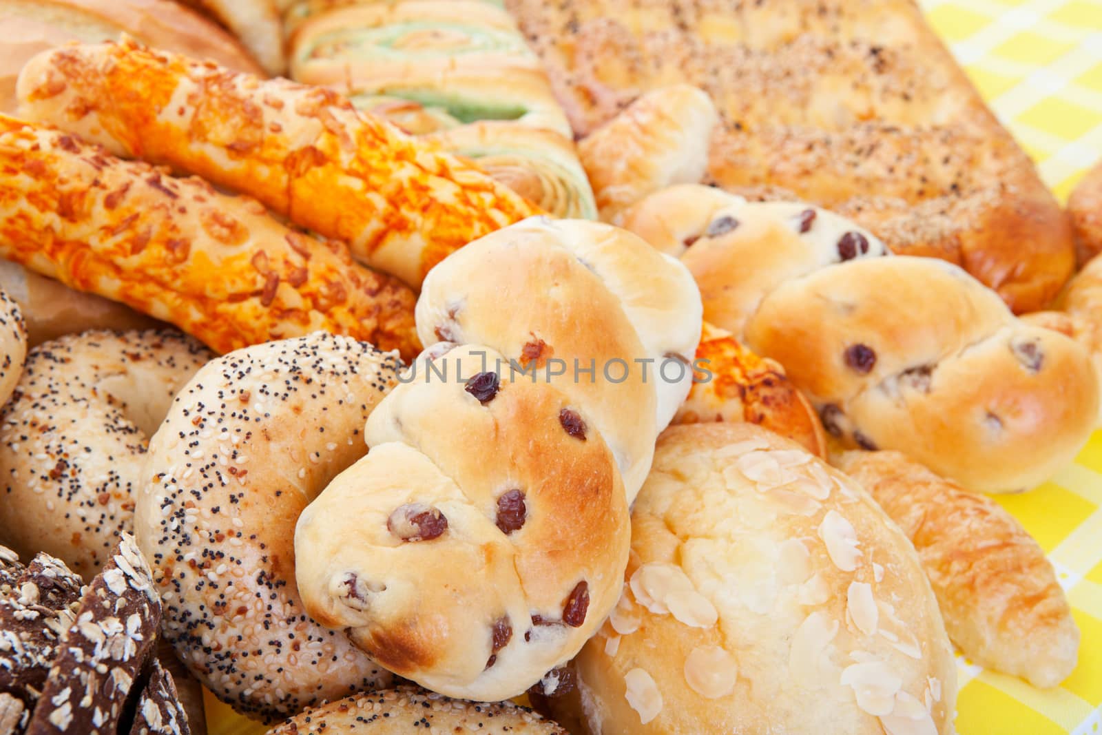 A group of international breads, including Almond Bun, Buko Pandan Loaf,  Italian Cheese Sticks, & Pumpernickel. 