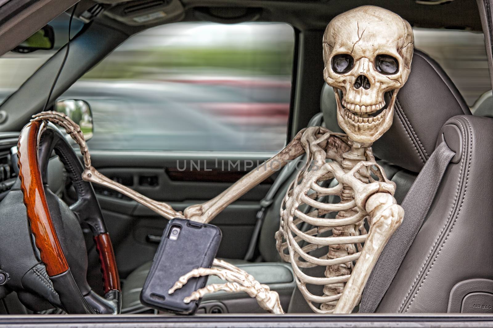 A skeleton behind the wheel of an SUV, distracted by his cell phone.  He is also not wearing a seatbelt.