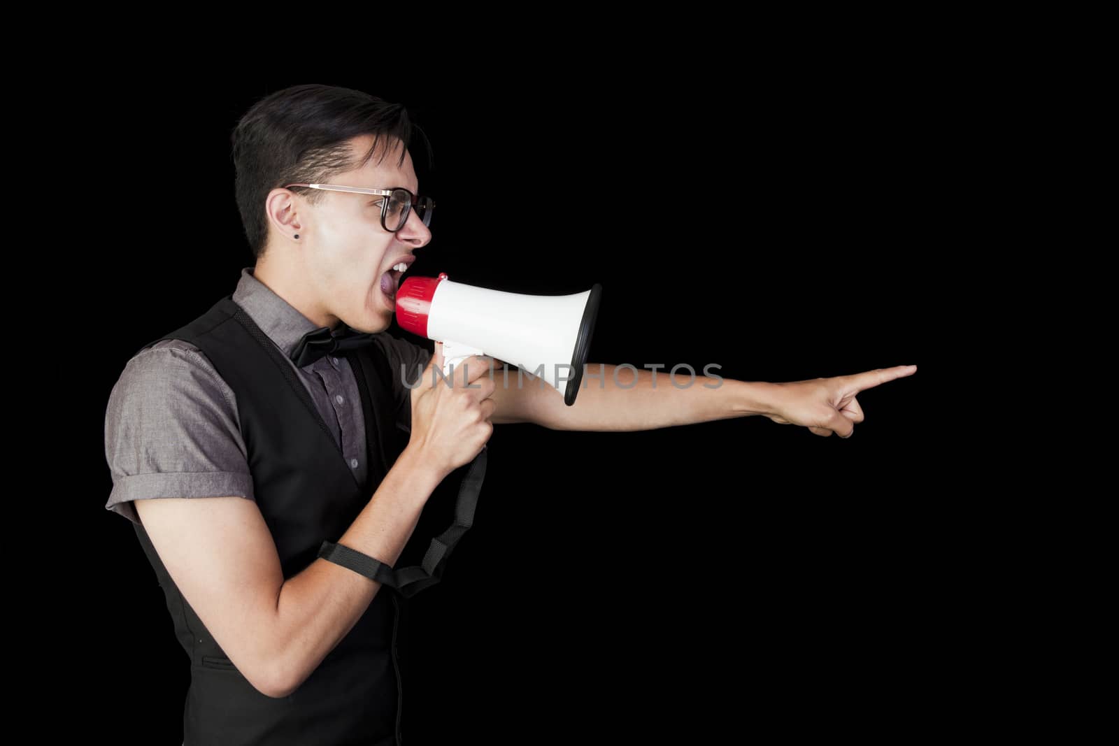 A young man shouting into a megaphone and pointing.