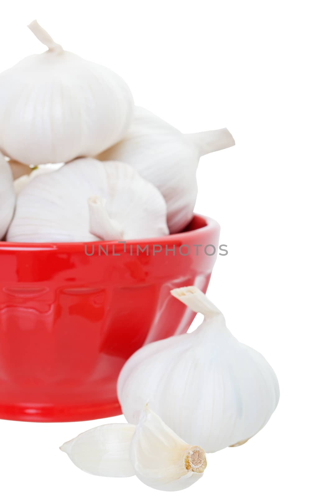 Freshly harvested whole garlic in a red bowl.  Shot on white background.