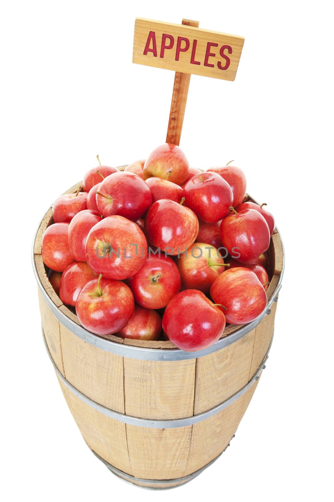 A market display of fresh apples in a  large wooden barrel.  Shot on white background.