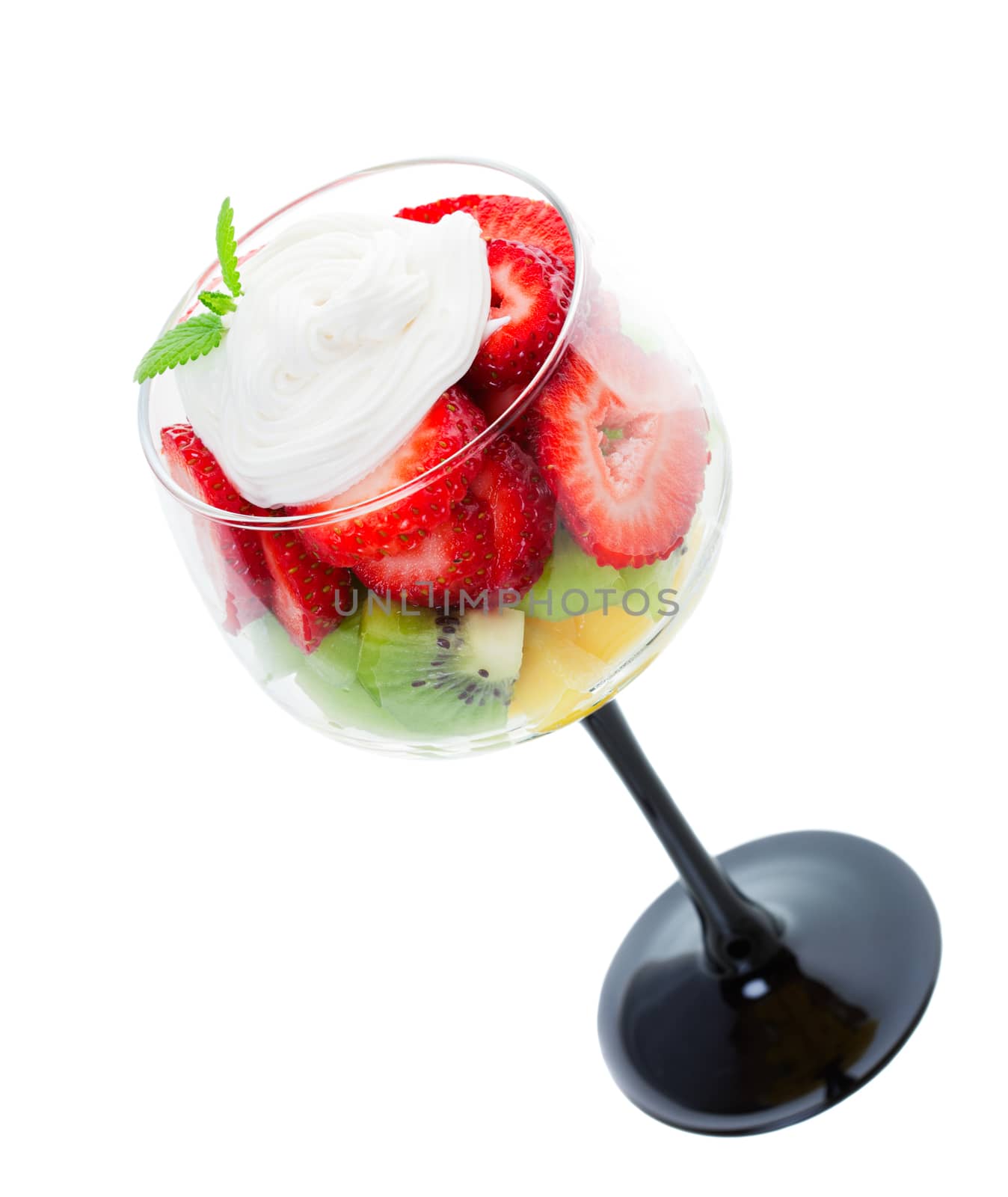 Fresh strawberries, kiwi, & pineapple, topped with whipped cream and a sprig of fresh mint, and served in an elegant wine goblet.  Shot on white background.