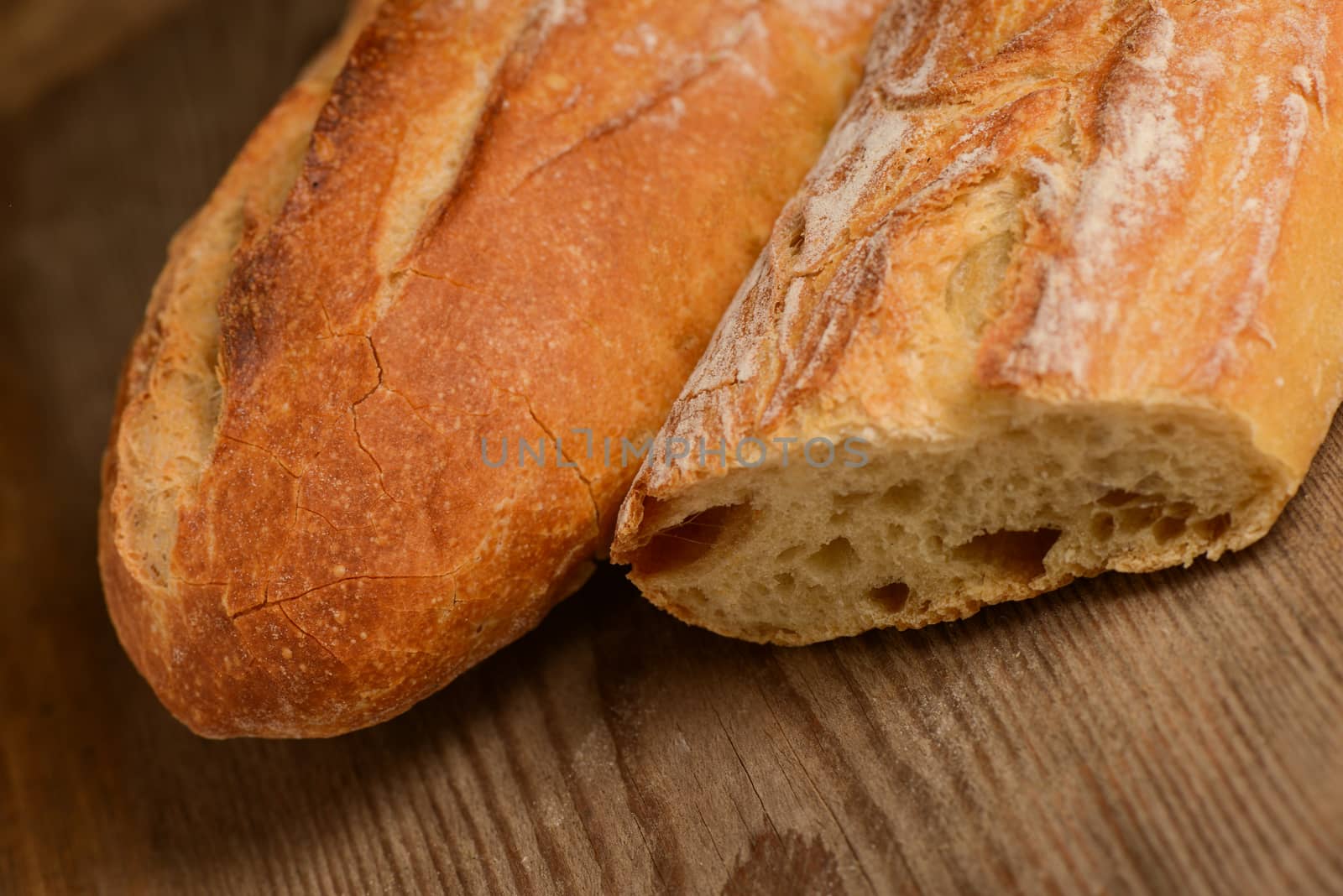 French crusty bread, isolated on a wooden plank background by FreeProd