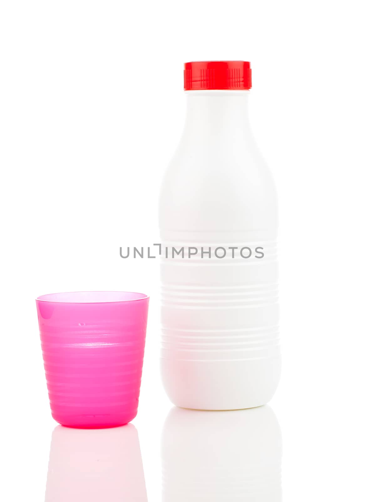 Milk bottle and plastic beaker isolated on white background by motorolka