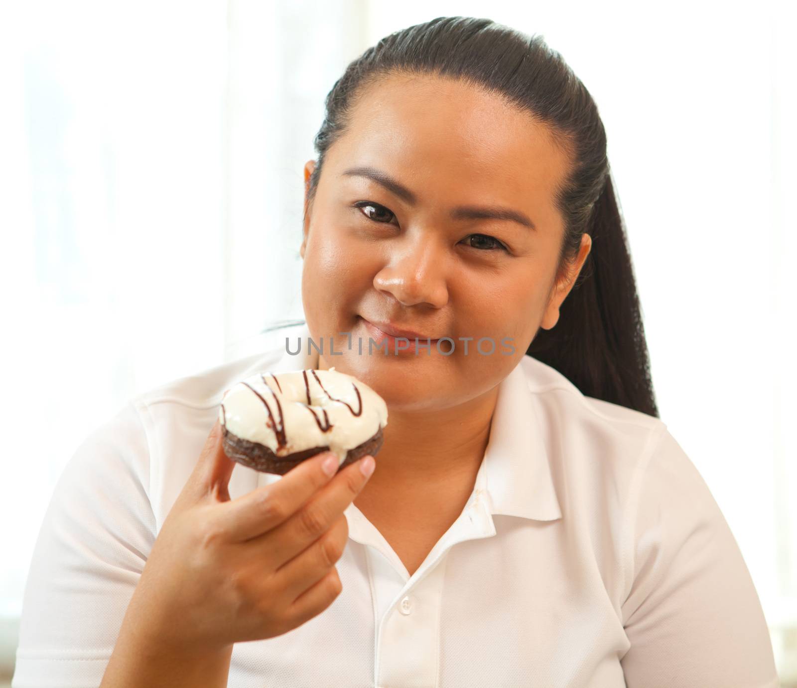 portrait of fat woman eating a donut