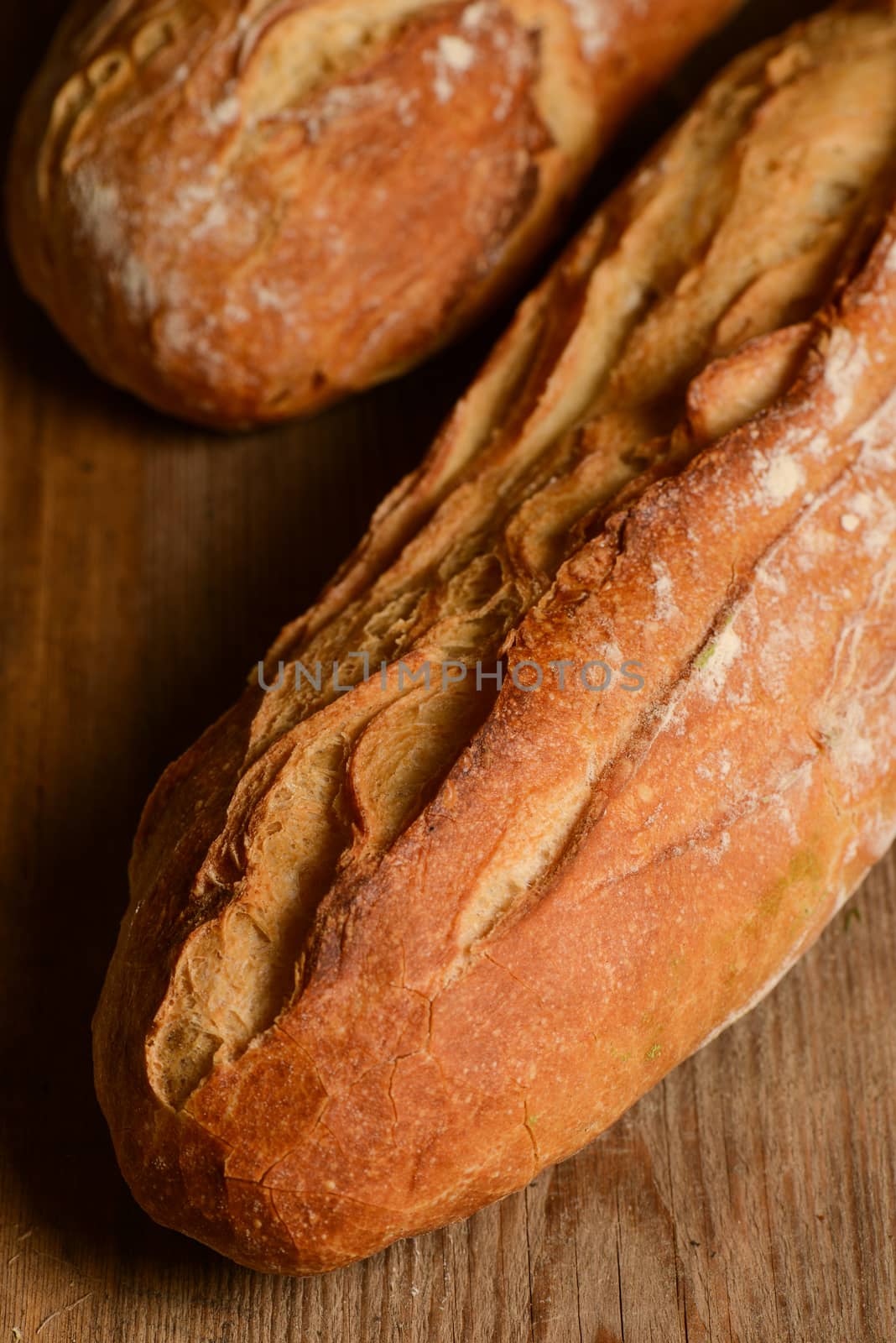 French crusty bread, isolated on a wooden plank background by FreeProd