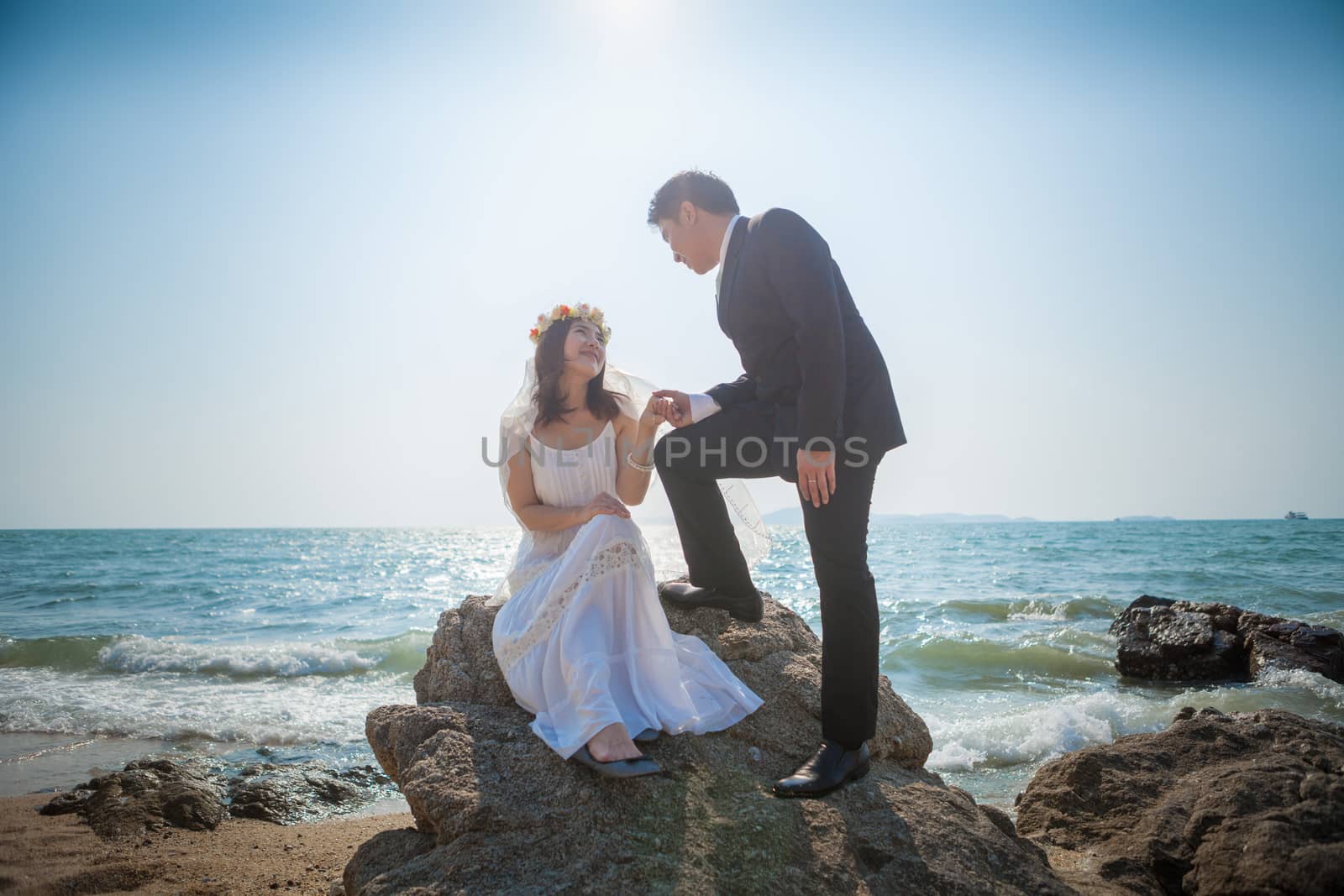 Beautiful asian couple on the beach in wedding dress