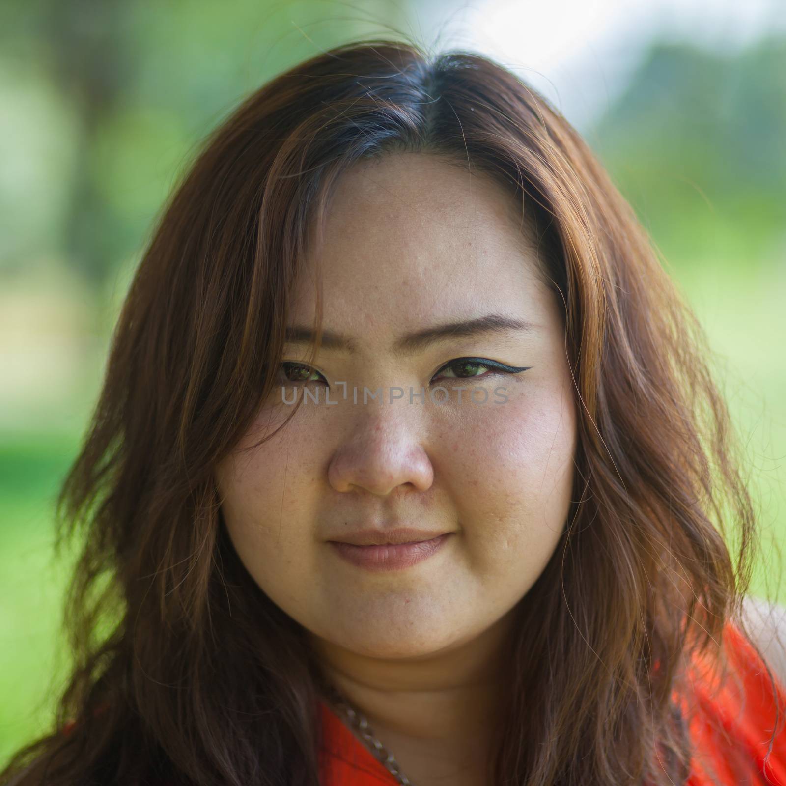 Close up of happy fatty asian woman outdoor in a park