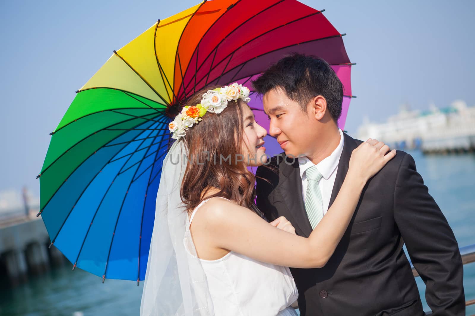 Beautiful asian couple on the beach in wedding dress