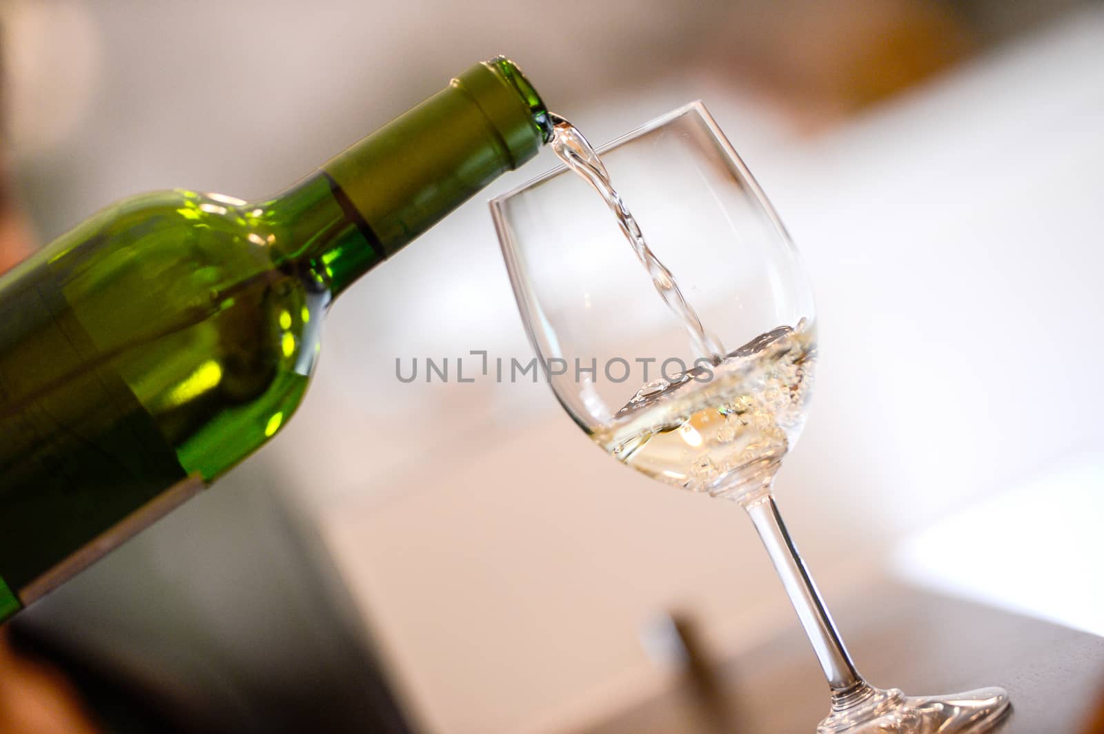 Tasting-White wine pour in a glass by FreeProd