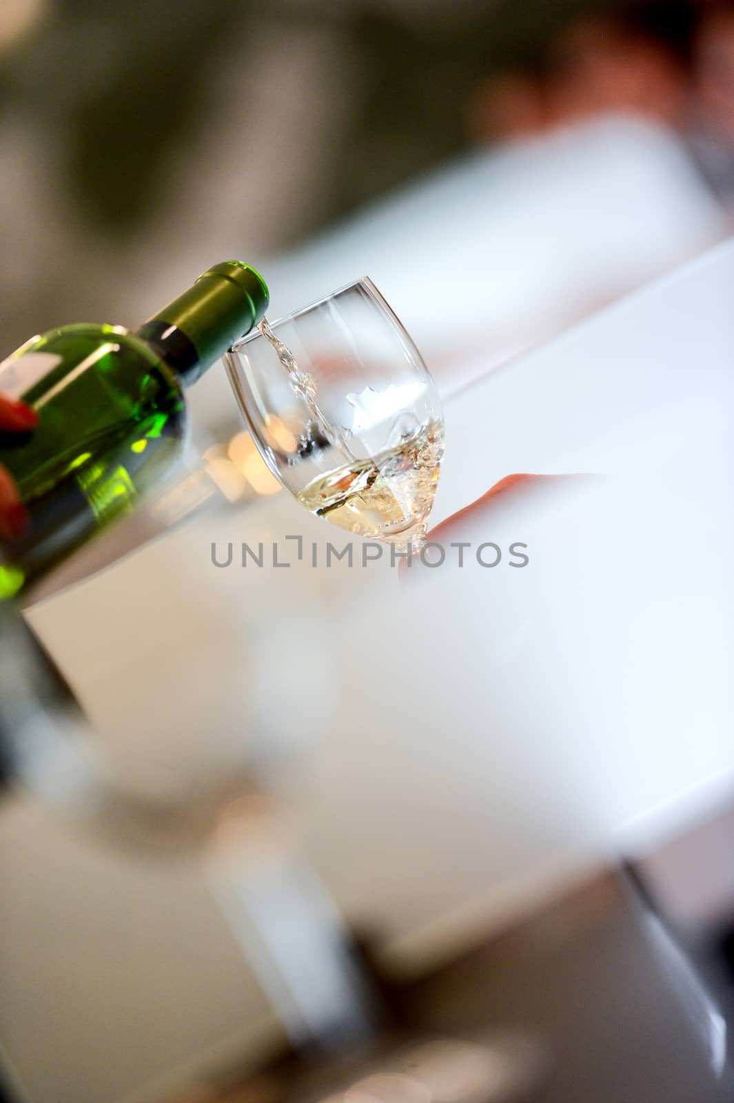 Tasting-White wine pour in a glass by FreeProd