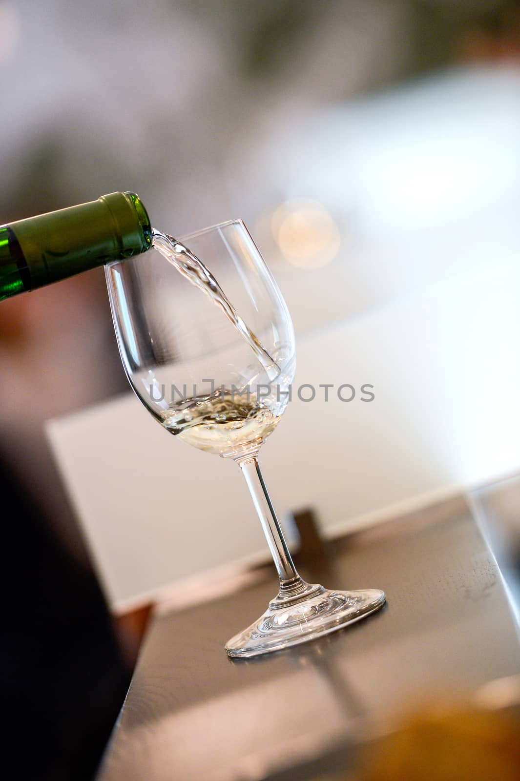 Tasting-White wine pour in a glass by FreeProd