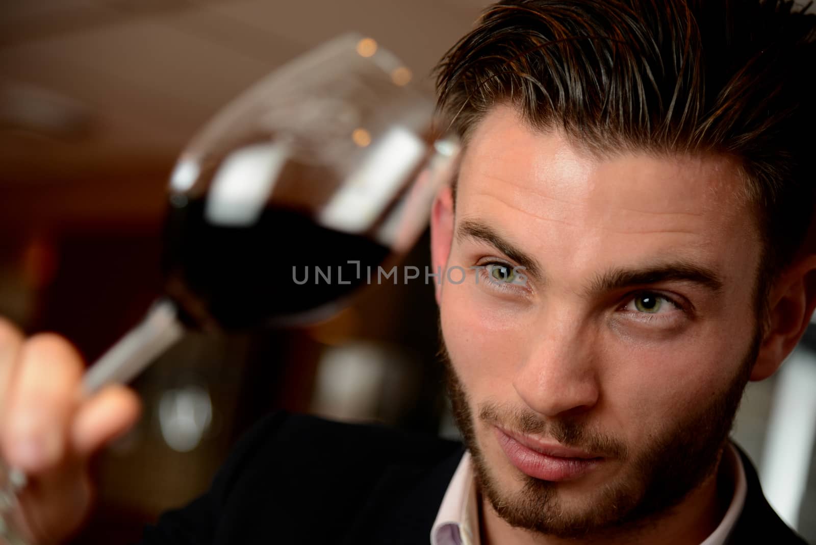 Young man with redwine glasses at celebration or party