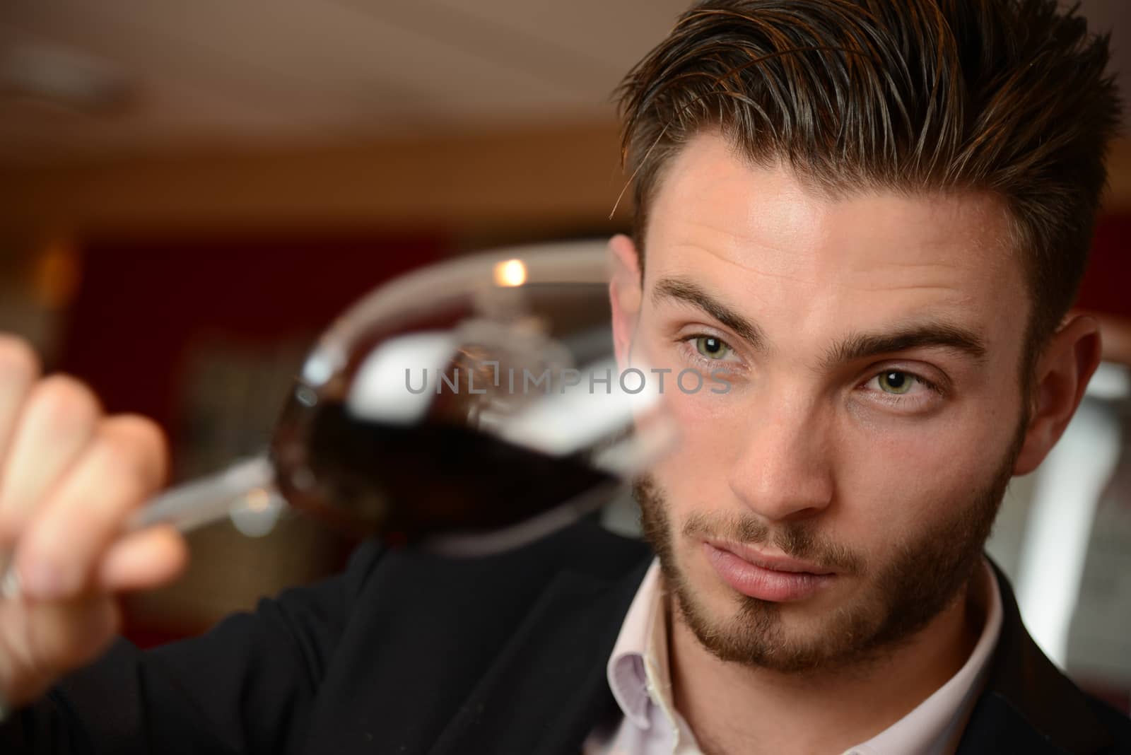 Young man with redwine glasses at celebration or party