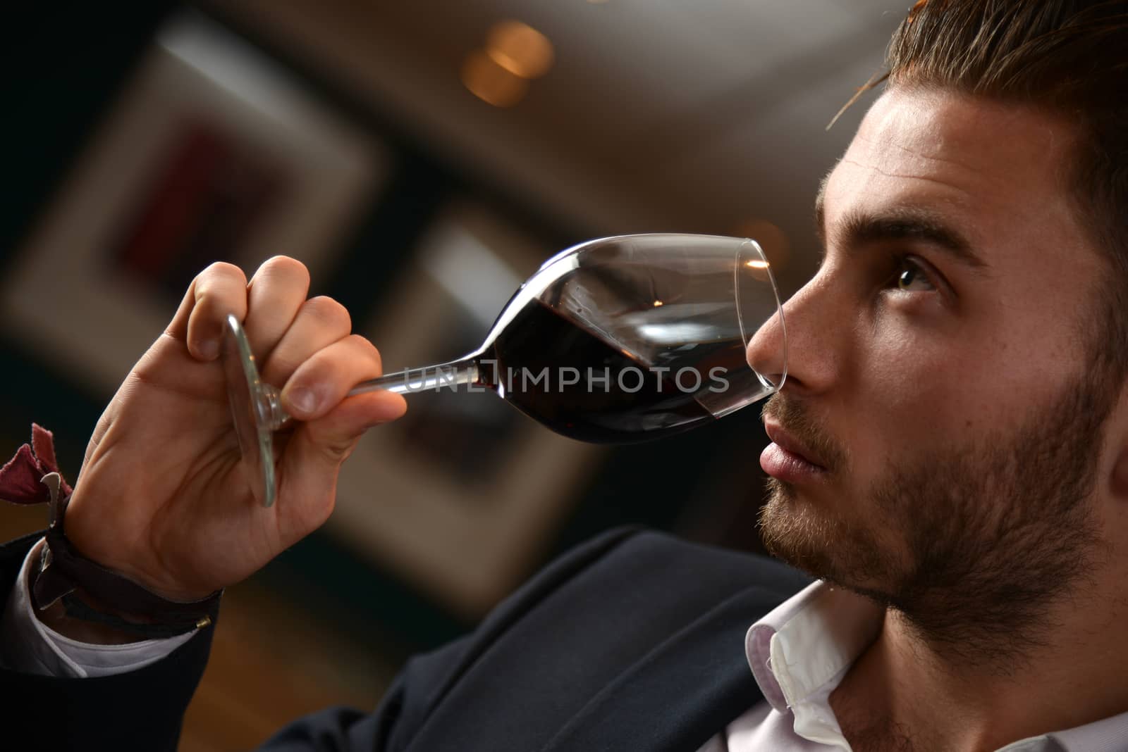 Young man with redwine glasses at celebration or party