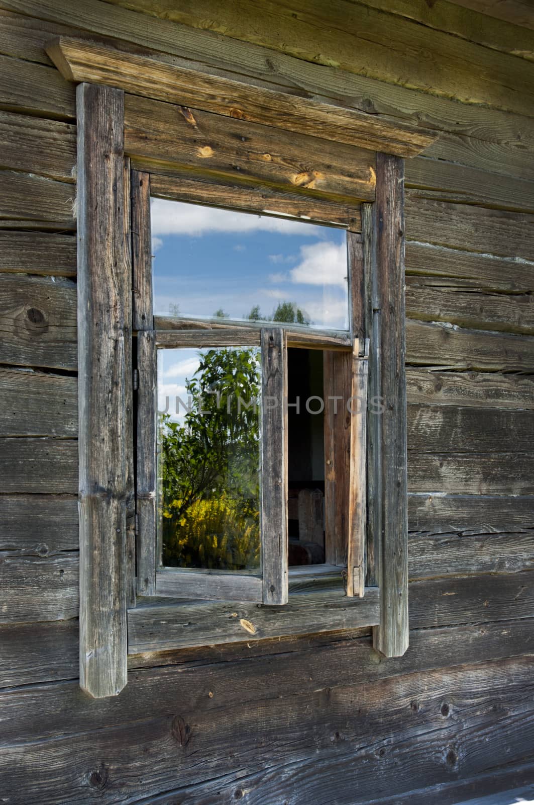 Old window on a wooden farm house wall