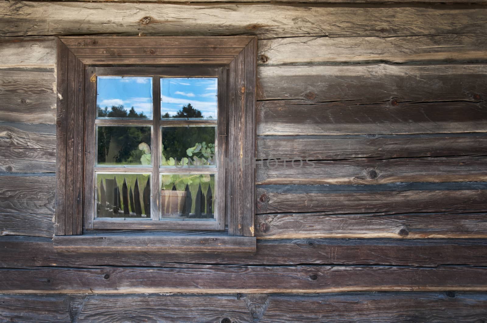 Old window on a wooden farm house wall