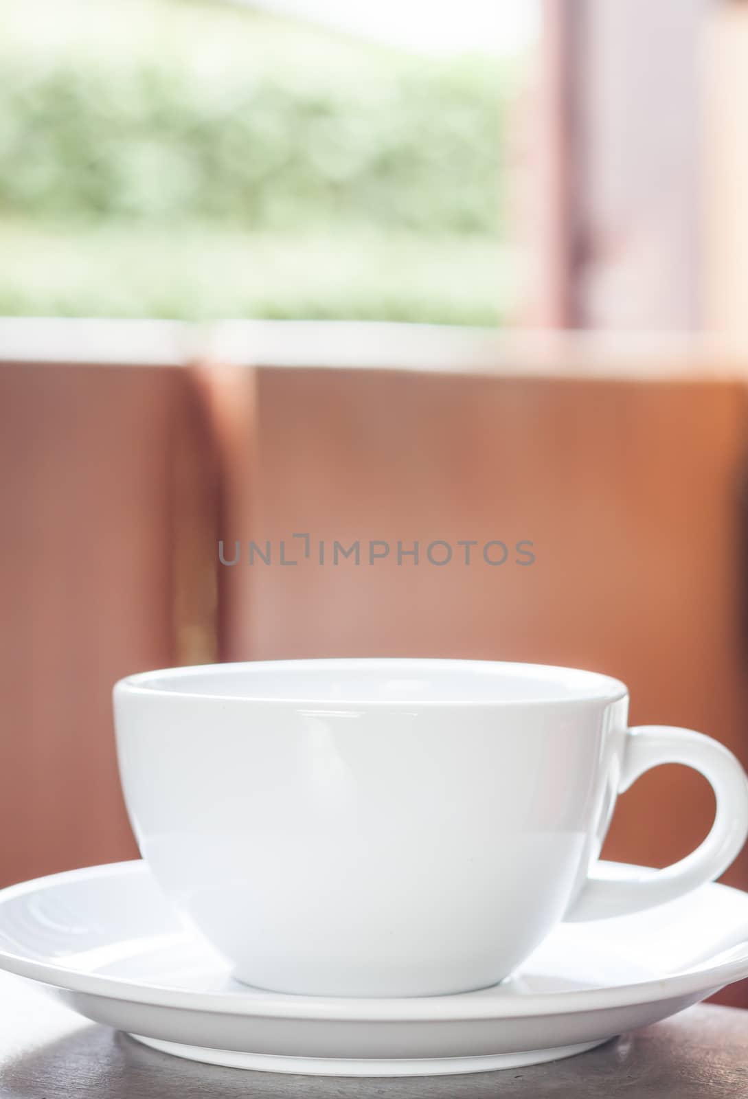 White coffee cup on the table by punsayaporn