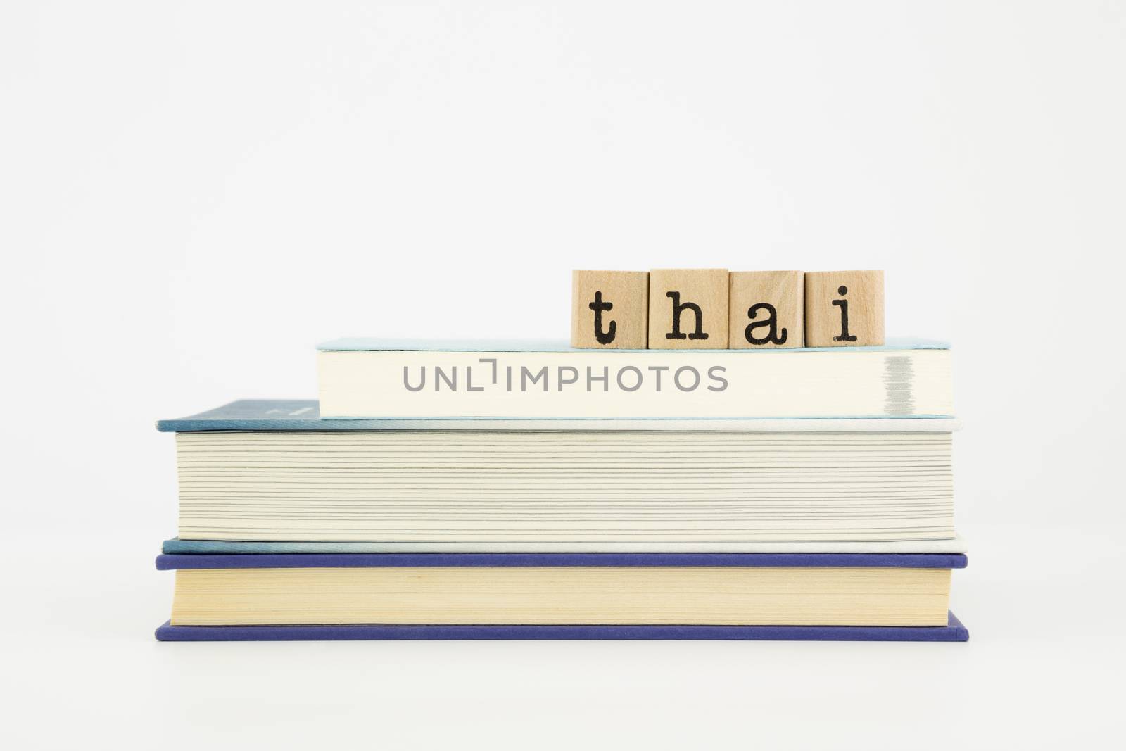thai word on wood stamps stack on books, language and study concept