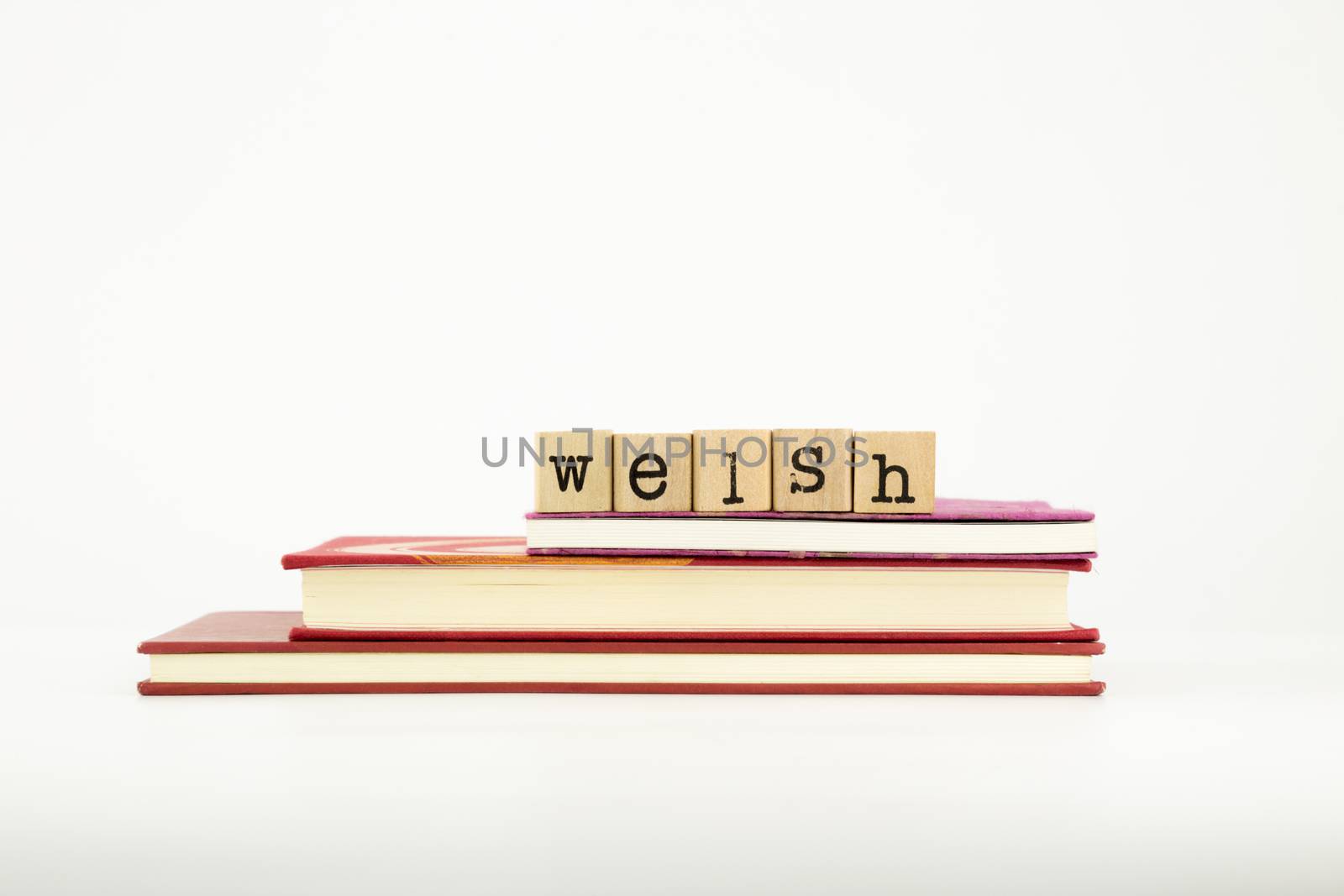 welsh word on wood stamps stack on books, language and study concept