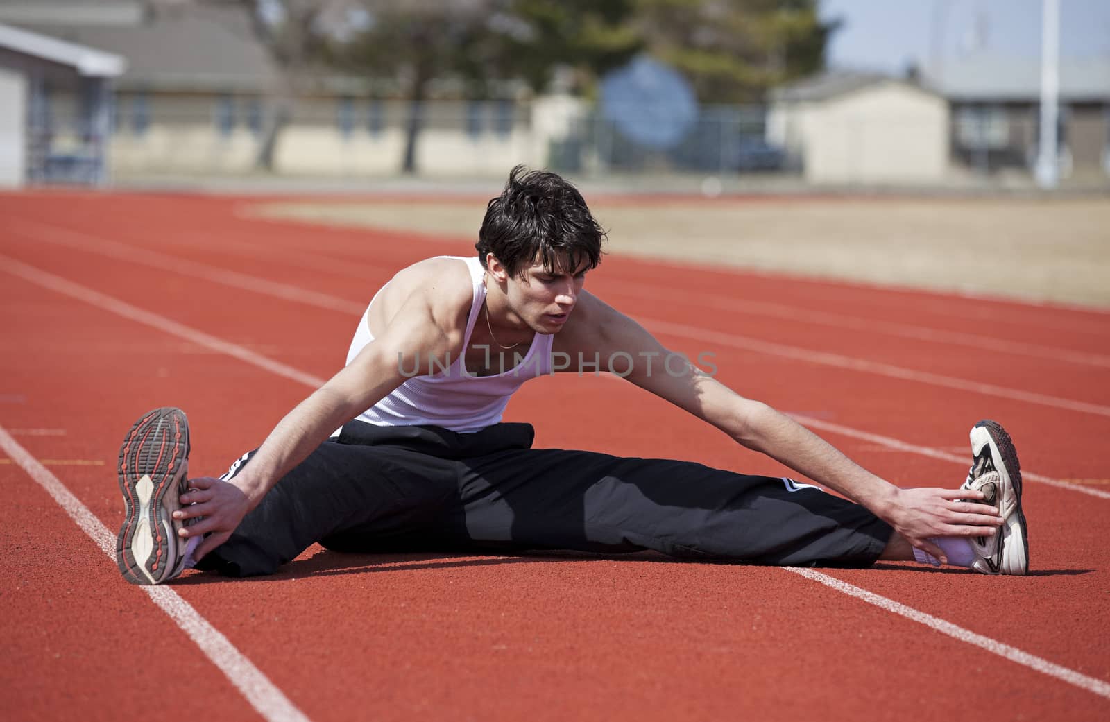 A young athlete doing a warmup leg stretch before a race.