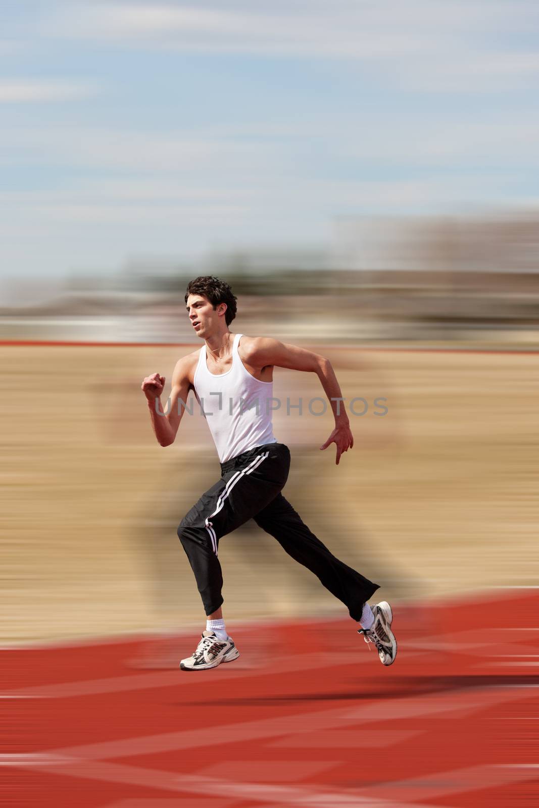 Young athlete running down the track with motion blur added.