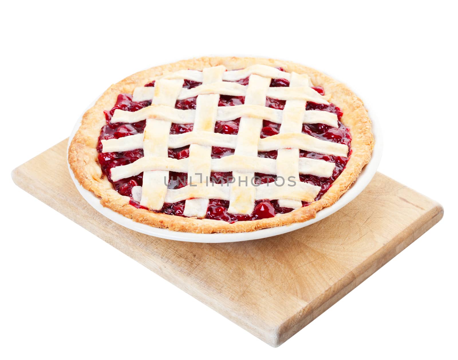 Delicious homemade cherry pie cooling on a wooden cutting board. Shot on white background.