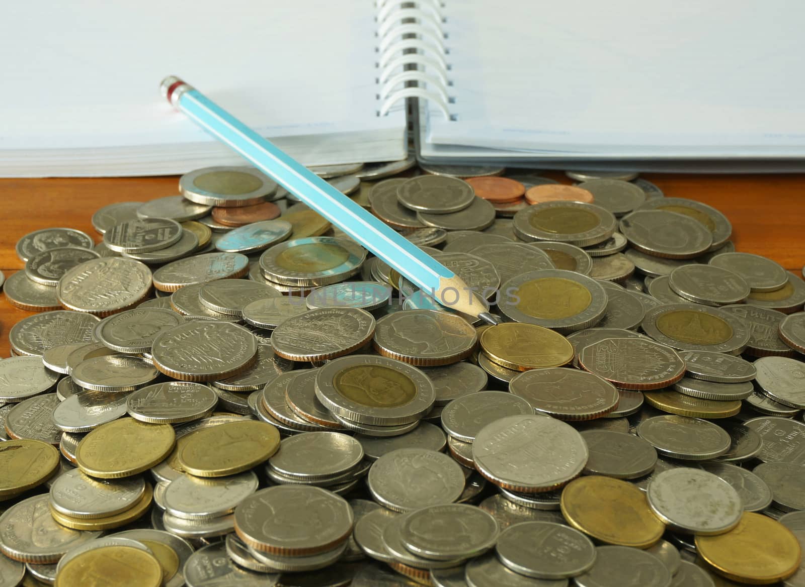 The amount of money placed on the table. A notebook and pencil to note the increase of money.                              