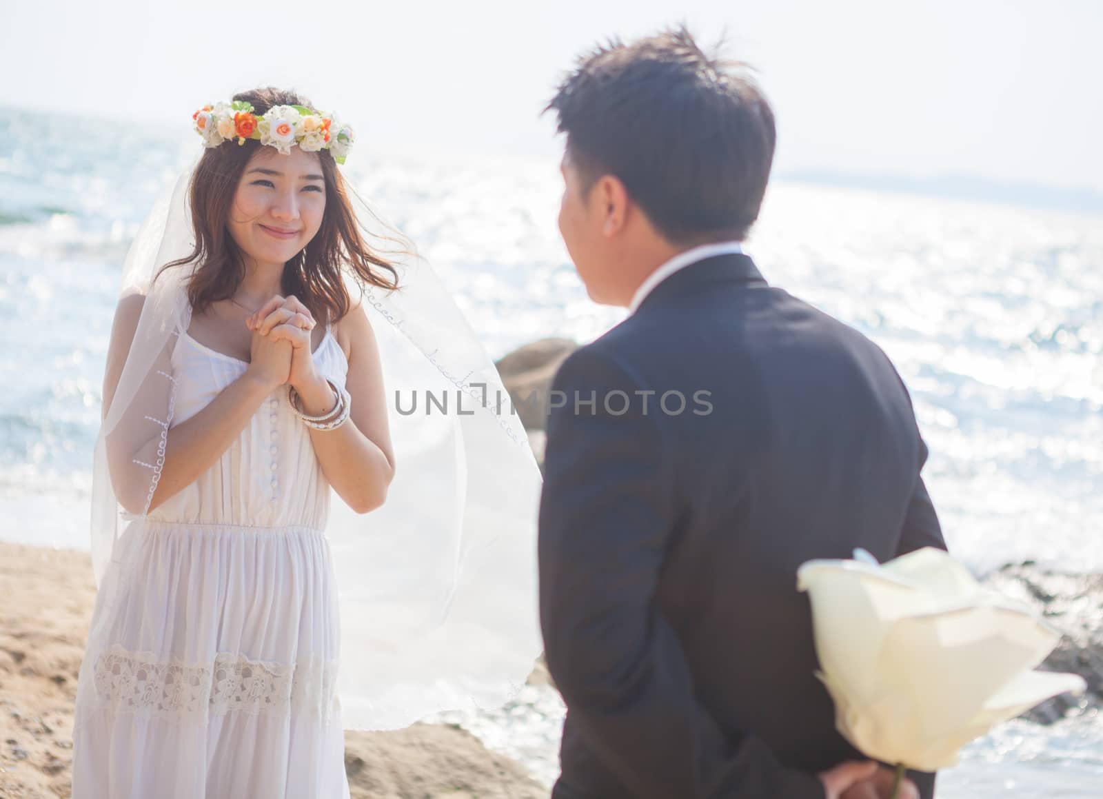 Beautiful asian couple on the beach in wedding dress
