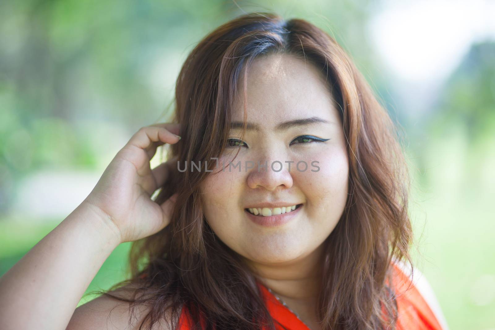 Close up of happy fatty asian woman outdoor in a park
